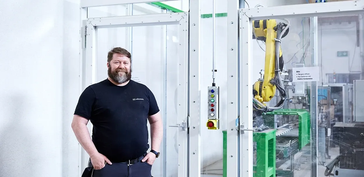 Mitarbeiter vor einer Palettierzelle in der Agrarshop Produktion