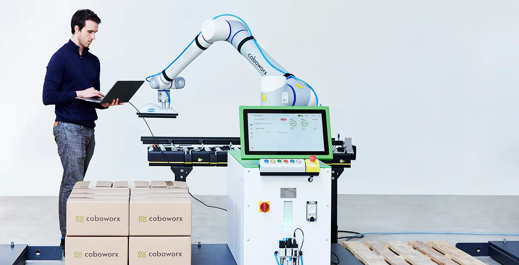 coboworx Mitarbeiter steht an der Cobot-Zelle mit Dobot-Roboter