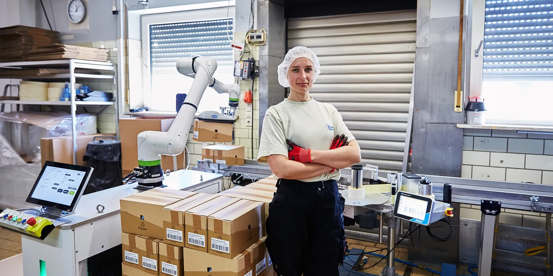 Panifactum Mitarbeiterin vor der Cobot-Palettierlösung in der Produktion