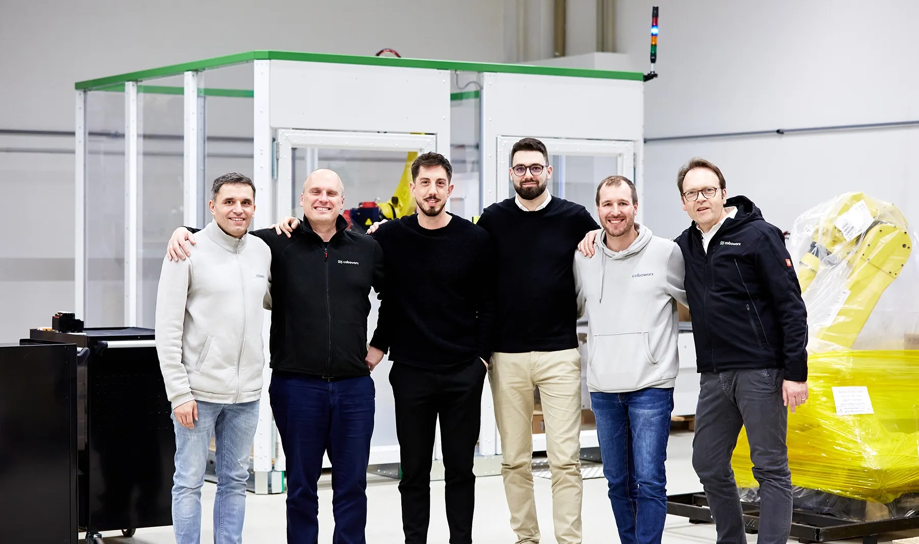 Gründer und Team vor Palettierzelle im Technikum